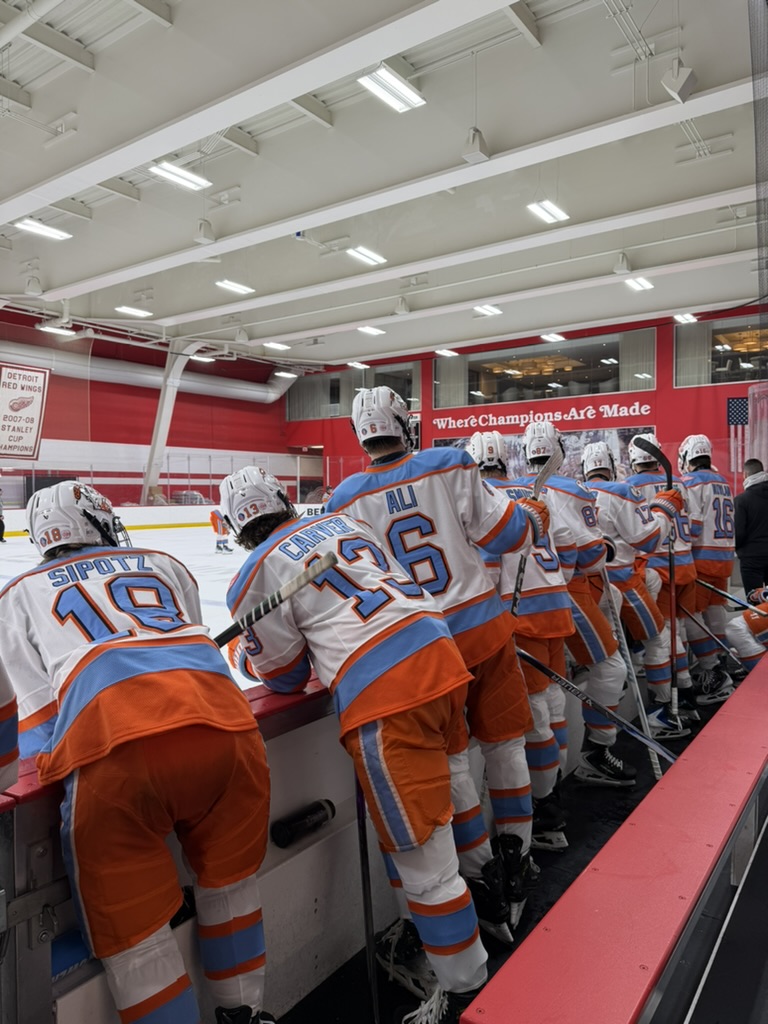 Little Caesars hockey players at the bench