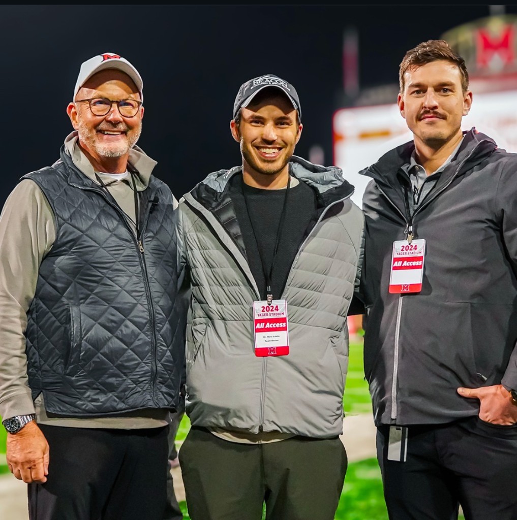 Dr. Howard with colleagues at a night football game